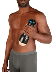 Man holding the assembled Kiiroo Control male masturbator at waist height, showing full device scale