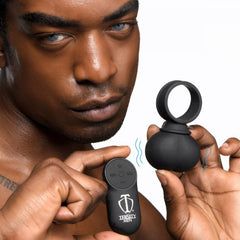 Man holding Trinity Men remote control alongside vibrating ball ring showing wireless operation