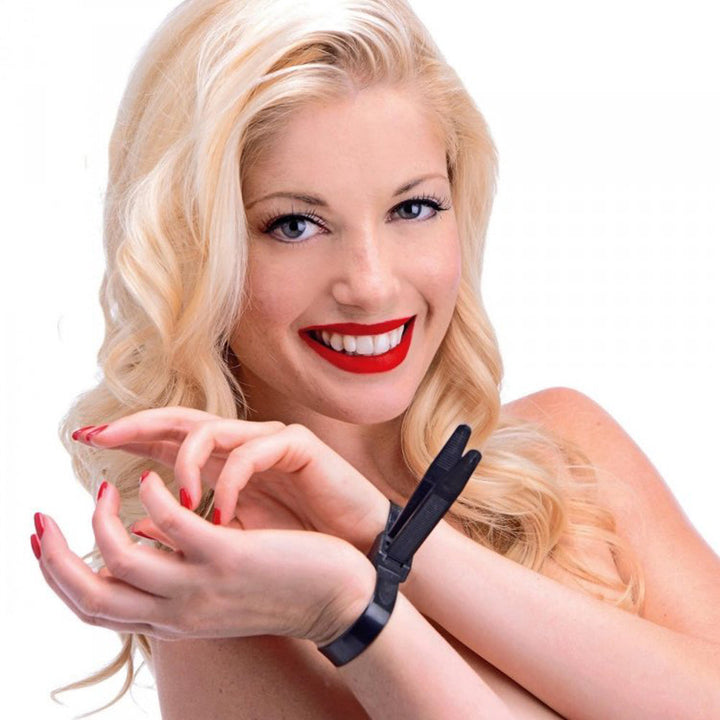 Master Series Misbehaved black zip tie police cuffs worn on wrists, shown on model smiling