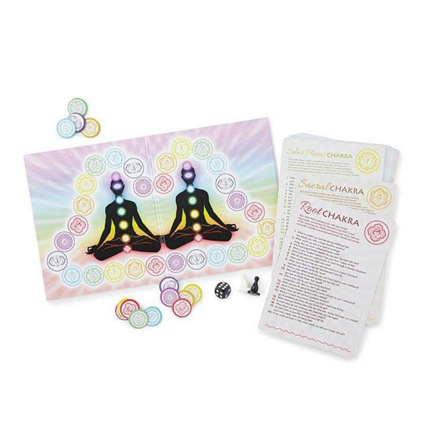 Mind Body & Soul game components showing colorful chakra board, dice, pawn, and Root and Sacral Chakra cards