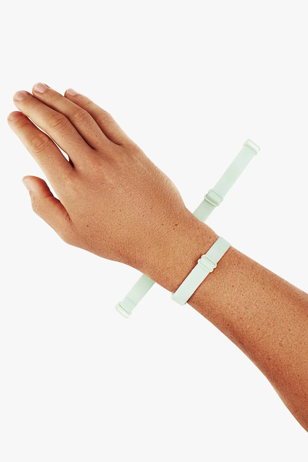 Mint adjustable elastic straps from the briefs shown wrapped around a model's wrist for scale