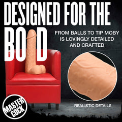 Moby dildo seated in red armchair with close-up inset highlighting realistic skin-like texture