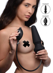 Model holding black inflatable anal plug and pump bulb showing min and max inflation sizes