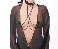 Model wearing lace collar with dual draping chains over sheer black bodysuit, front view