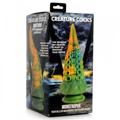 Monstropus tentacled monster silicone dildo displayed beside its retail box packaging on white surface