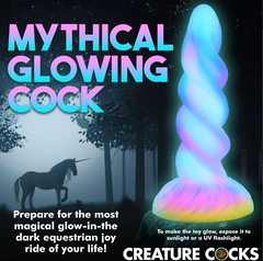 Moon Rider glowing unicorn dildo shown luminescent beside silhouette of a unicorn at night