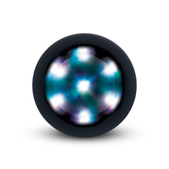 Close-up of multi-color LED light base glowing white and blue on butt plug