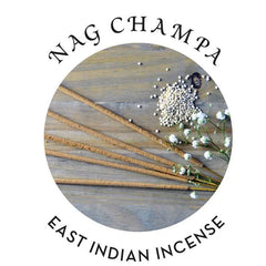 Nag Champa East Indian incense sticks fanned beside white flowers and seeds on wood