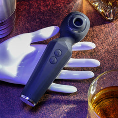 Navy blue Rainbow Sucker wand resting on decorative hand prop, showing faceted body and button layout