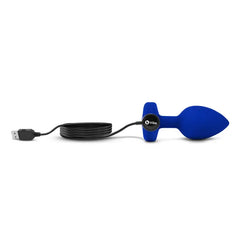 Navy jewel plug connected to USB charging cable showing magnetic charge port