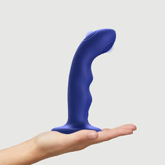 Night blue Strap-On-Me Wave dildo balanced on open palm showing compact medium size