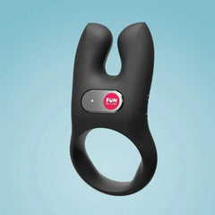 NŌS black silicone dual-motor cock ring floating on light blue background, angled front view
