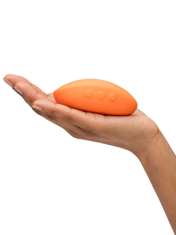 Open palm holding We-Vibe Temp face-up displaying three control buttons and compact egg-shaped form