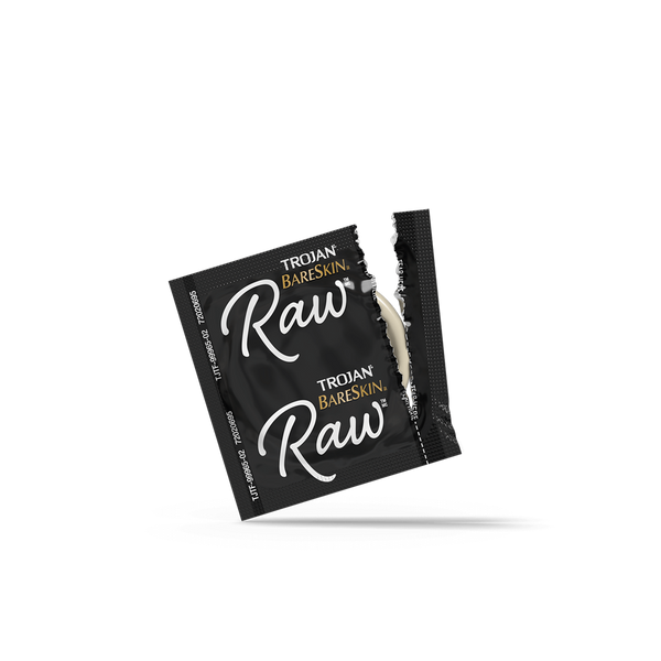 Open Trojan BareSkin Raw individual foil wrapper in black, showing lubricated latex condom inside