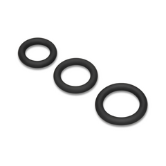 Overhead diagonal view of three black thick-walled silicone cock rings varying in diameter