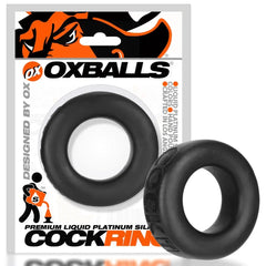 Oxballs COCK-T black cock ring displayed beside its retail card packaging for scale reference
