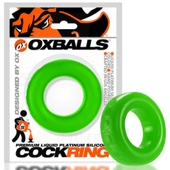 Oxballs COCK-T slime green cock ring beside its retail packaging, showing relative size and profile