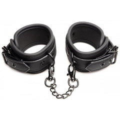 Close-up of padded black faux-leather wrist cuffs connected by a gunmetal chain link