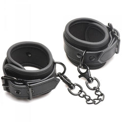 Close-up of padded faux-leather wrist cuffs with black chain link connector and adjustable buckle