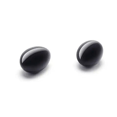 Pair of glossy black obsidian yoni eggs displayed side by side, oval egg shape