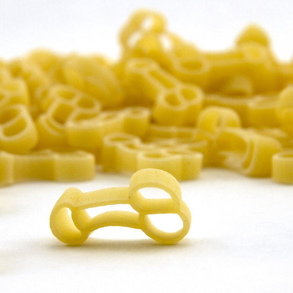 Penis Pasta uncooked novelty-shaped durum wheat pieces arranged on a white surface