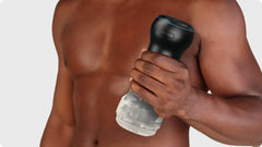 Person holding assembled Kiiroo Powerblow Pocket Stroker Crystal upright, showing full product scale in hand
