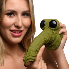 Person holding Creature Cocks Swamp Monster dildo showing large googly eyes and scaly base detail