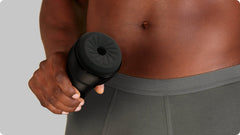 Person holding Feel Pocket Stroker at waist level showing compact ergonomic fit in one hand