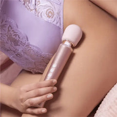 Person in lavender lace lingerie holding Le Wand Petite Massager against hip area