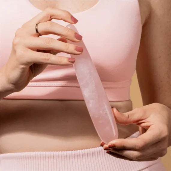 Person in pink activewear holding the rose quartz Crystal Slim Wand at waist level