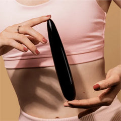 Person in pink crop top holding black obsidian Crystal Slim Wand against torso for scale