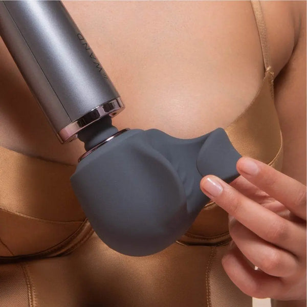 Person using the Le Wand Loop silicone attachment on a massager wand, shown in a lifestyle context
