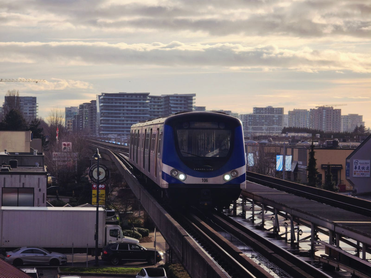 Canada Line SkyTrain crossing above a Richmond, BC street at dusk