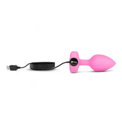 Pink anal plug connected to USB magnetic charging cable for recharging