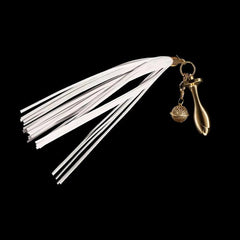 Pink Elephant white leather flogger tail plug kit with gold rose-shaped plug and filigree bell charm on black background