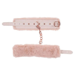 Pink faux-fur handcuffs laid flat showing adjustable leather band and rose gold link chain
