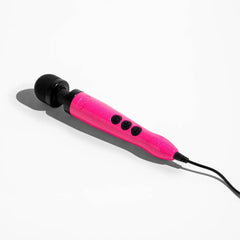 Pink glitter Doxy wand massager lying at an angle showing corded power connection and button controls