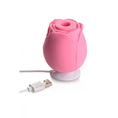 Pink rose silicone vibrator on charging base with USB charging cable connected