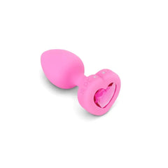 Close-up of pink silicone anal plug showing heart-shaped jewel base detail