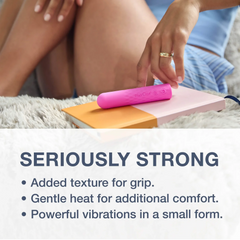 Pink super bullet resting on a notebook beside a person's hand, highlighting diamond-pattern grip texture