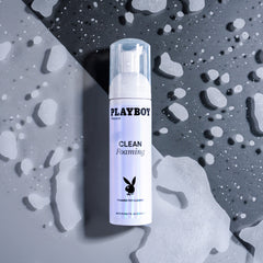 Playboy Clean Foaming 7oz pump bottle surrounded by foam and water droplets