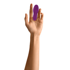 Purple Evolved finger clitoral stimulator worn on index finger, shows compact wearable silicone design