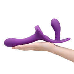 Purple silicone dual-ended dildo resting on an open palm to illustrate overall size and ergonomic shape
