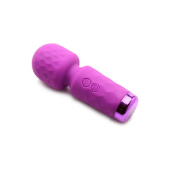Purple silicone mini wand at a low angle displaying honeycomb-textured head and dual buttons