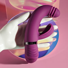 Purple silicone rabbit vibrator held in white mannequin hand showing ergonomic grip and dual arms