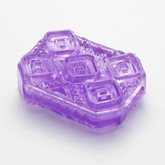 Purple translucent Tenga Uni Amethyst pad removed from packaging, showing layered square-cut texture