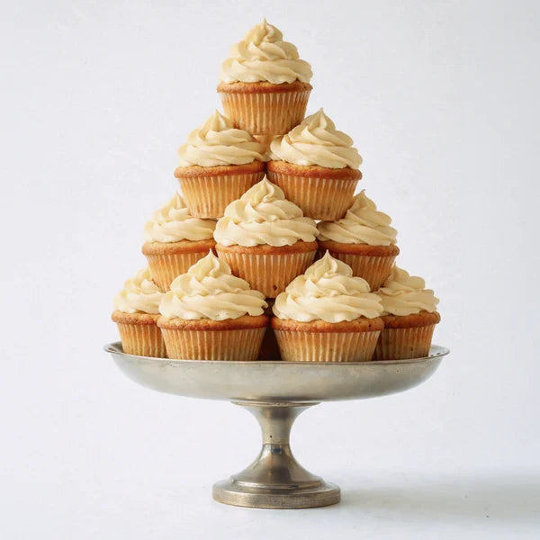 Pyramid of frosted vanilla cupcakes on a silver cake stand evoking the dessert-inspired scent of the lubricant