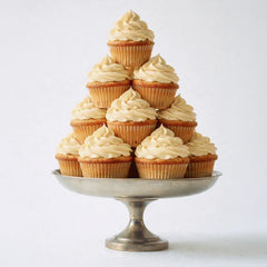 Pyramid of frosted vanilla cupcakes on a silver cake stand evoking the dessert-inspired scent of the lubricant
