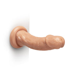 Realistic dildo mounted horizontally on flat surface via suction base, demonstrating hands-free use