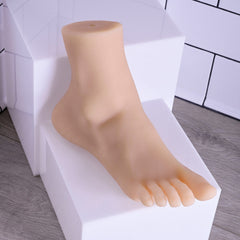 Realistic foot stroker displayed upright on white platform showing full side profile
